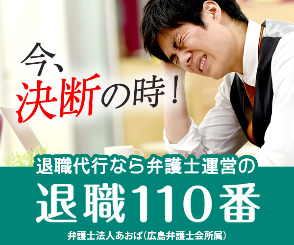 ストレスを感じている男性が頭を抱えるシーン。背景にはパソコンとデスクの一部が見える。