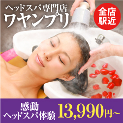 リラックスしてヘッドスパを受ける女性の画像。頭にシャワーをかけられ、バラの花びらが入った洗面器の前に座っています。