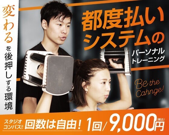 男性トレーナーと女性クライアントがパーソナルトレーニングを行っている様子。トレーナーが器具を持ち上げるのを手伝っている。背景にはジムの設備が見える。