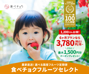 子供が新鮮なイチゴを口に運ぶ様子を捉えた写真。背景には美しいイチゴの畑が広がっている。