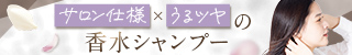 女性が髪の毛を整えながら微笑んでいる姿。背景には柔らかい色合いのデザインが施されたバナーが見える。