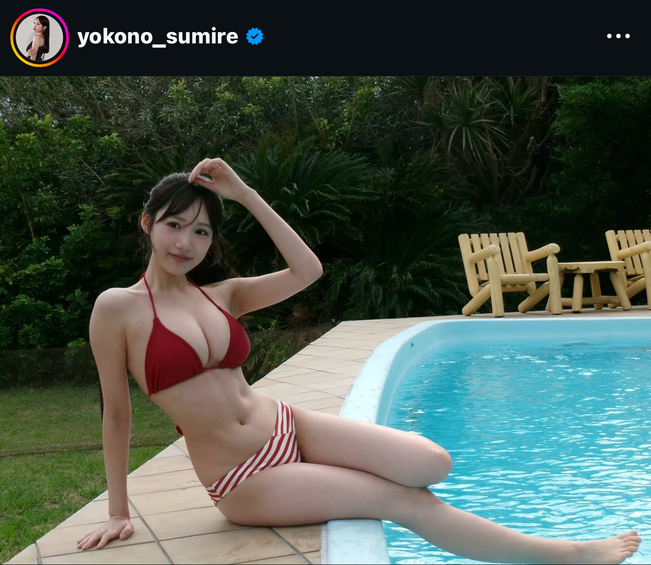 赤いビキニを着た女性がプールサイドに座り、手を頭にかざして微笑んでいるシーン