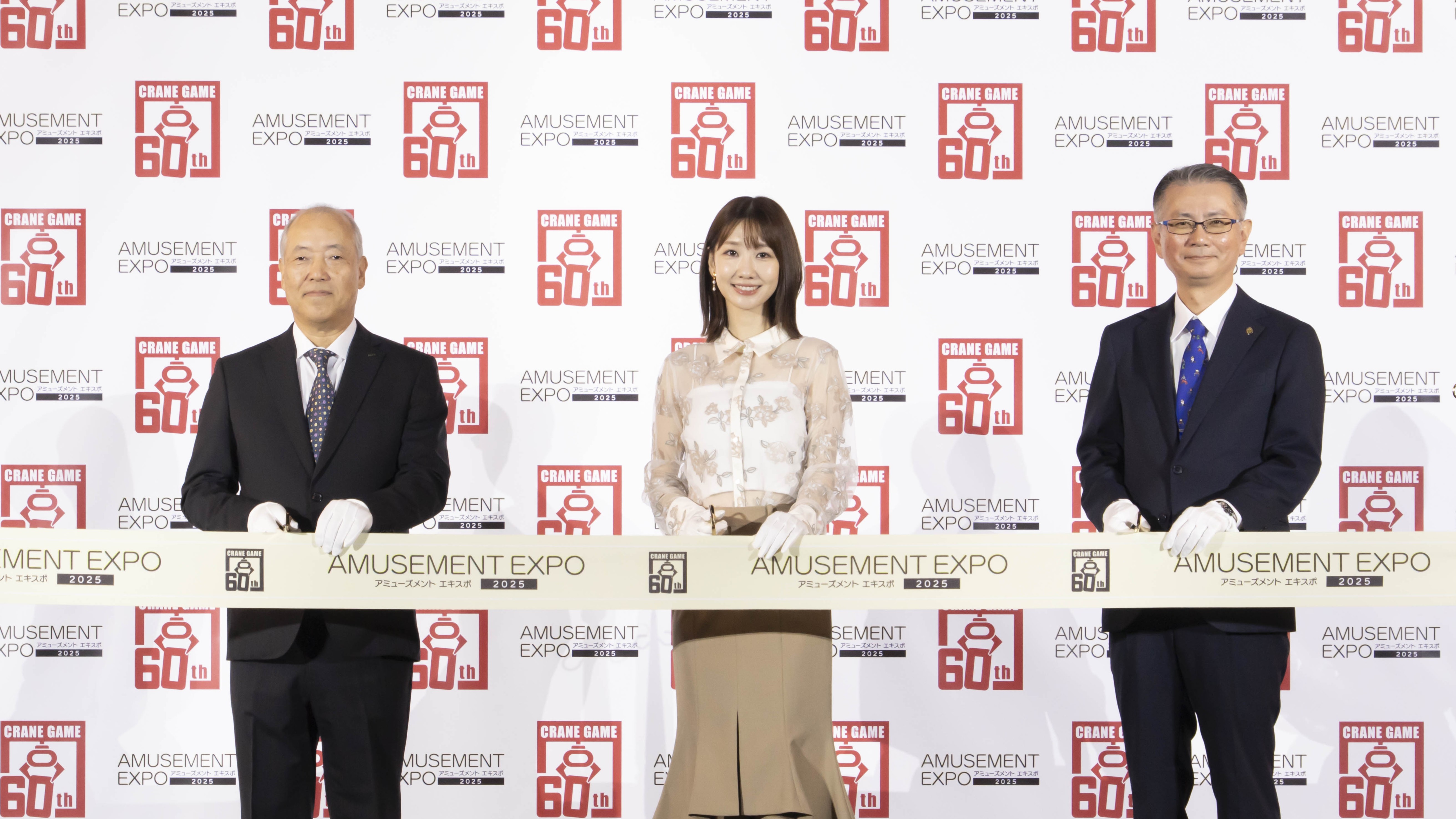 クレーンゲーム60周年記念で、3人がテープカットを行うセレモニーの様子。